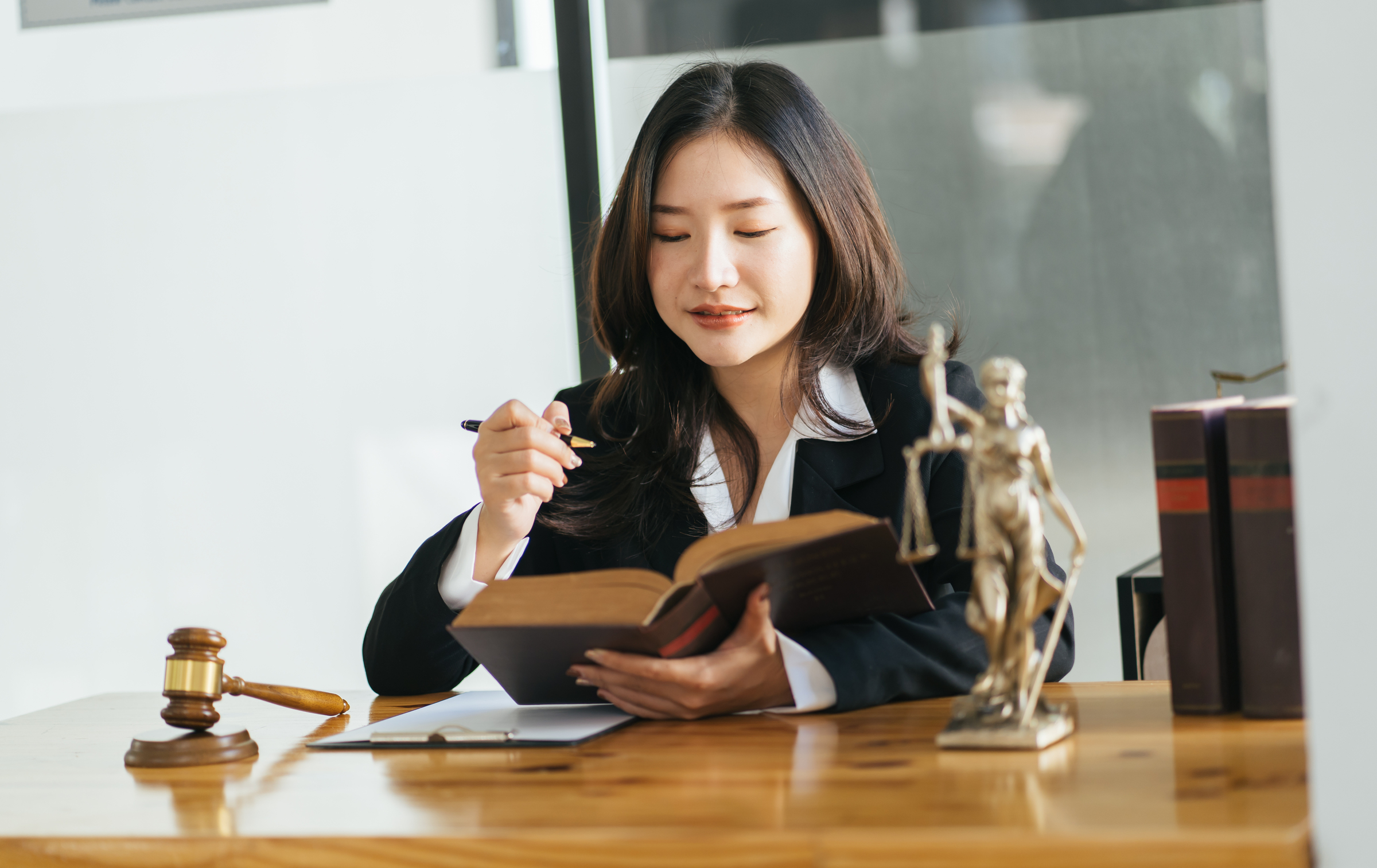 Female lawyers open and reading with a law book at her workplace.